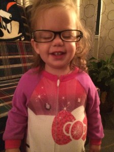 Katherine wearing mommy's reading glasses.