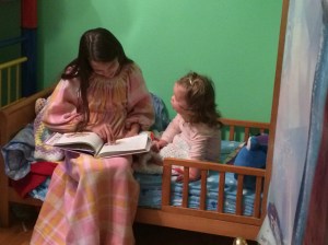Natasha reading to Katherine in her new bed.